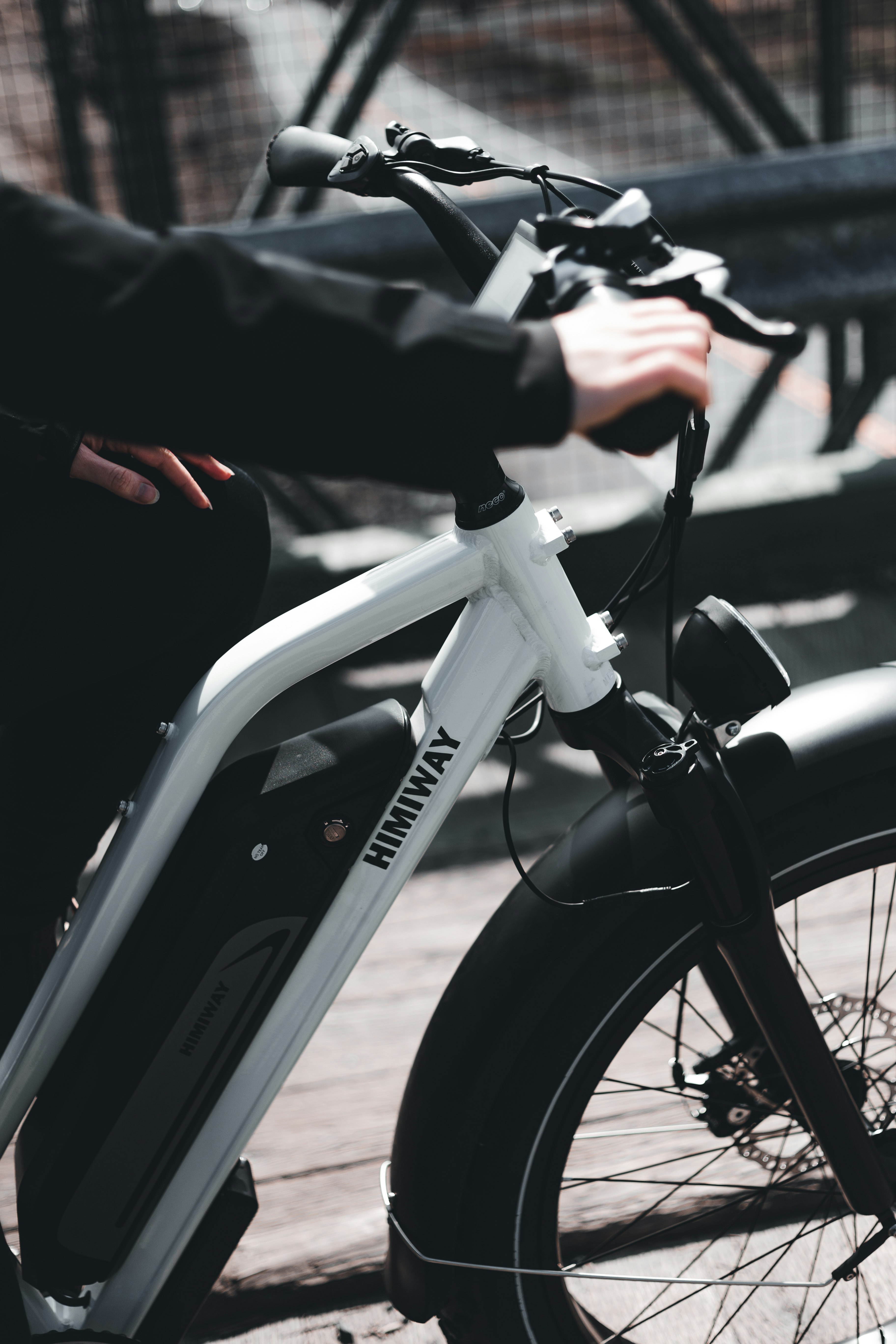 person in black jacket riding white bicycle during daytime